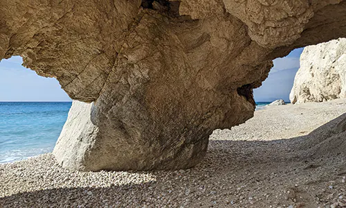 Arches formed in the rocks on the south side of Megali Petra Beach